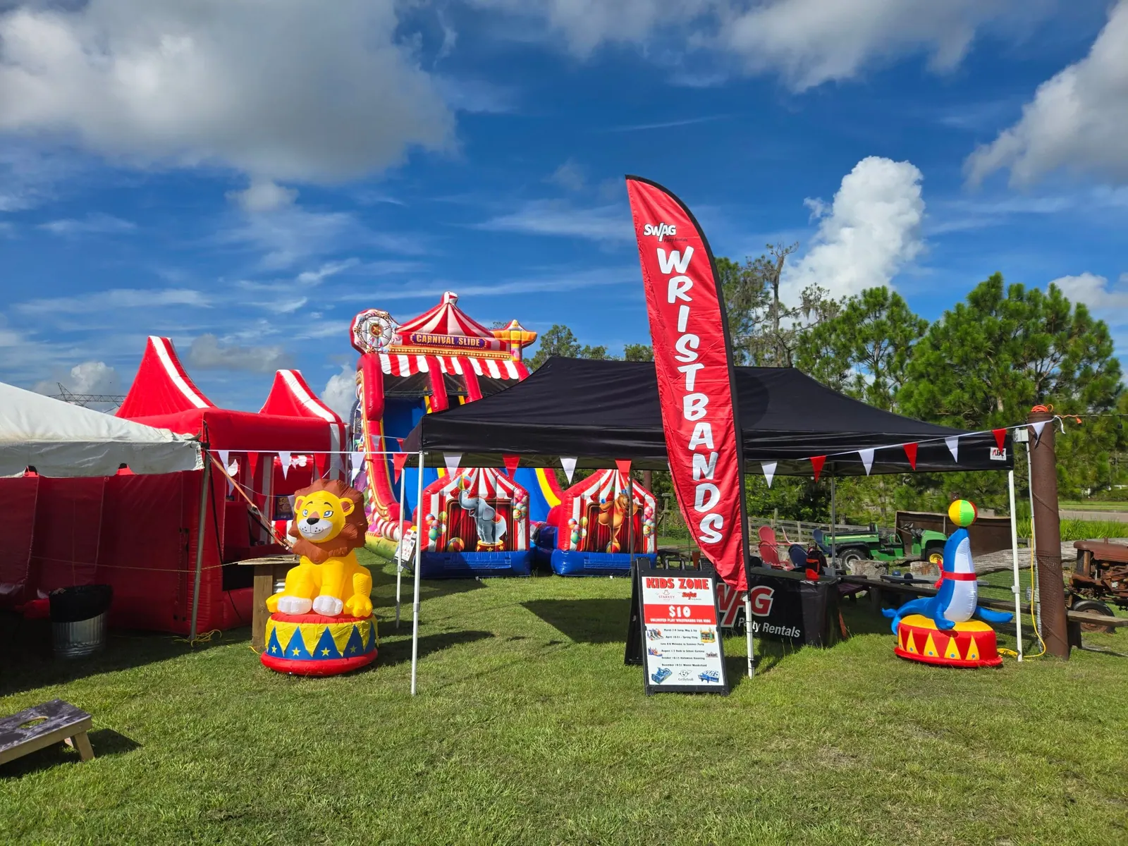 A SWAG Kids Zone with red tents and carnival inflatables